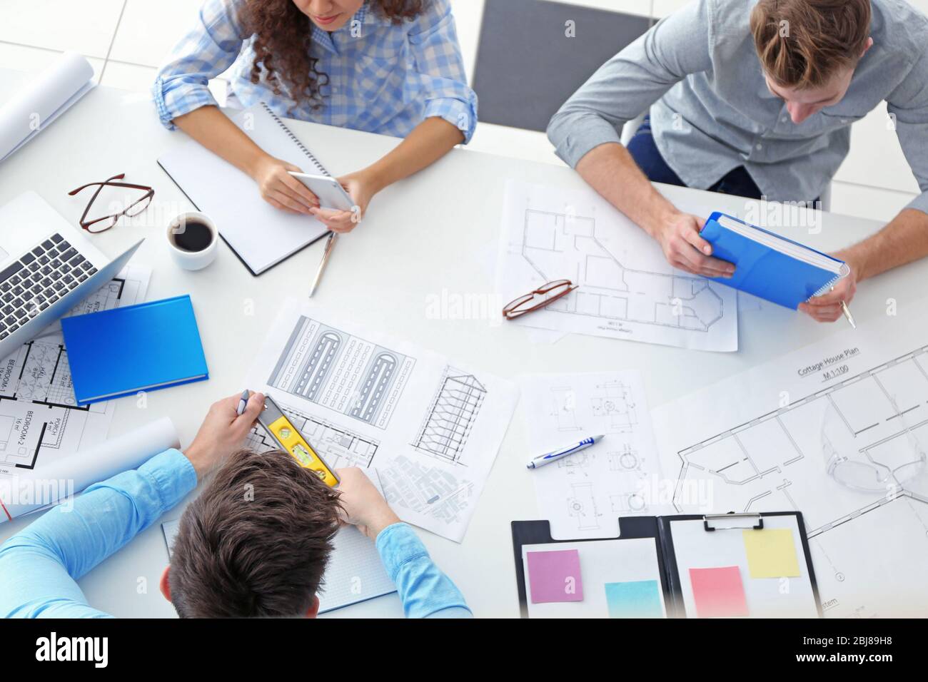Team of professional engineers working with blueprints Stock Photo - Alamy