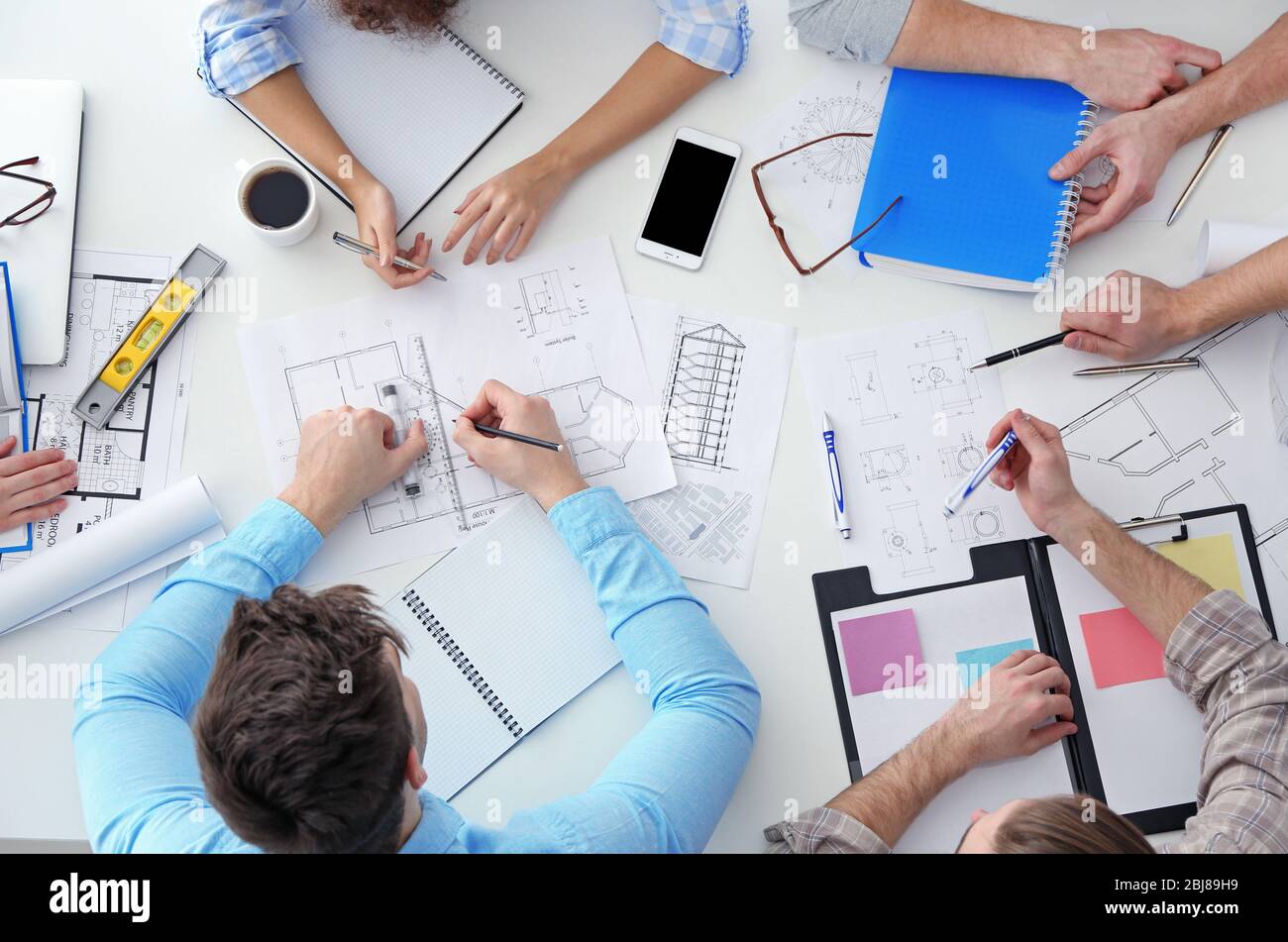 Team of professional engineers working with blueprints Stock Photo - Alamy