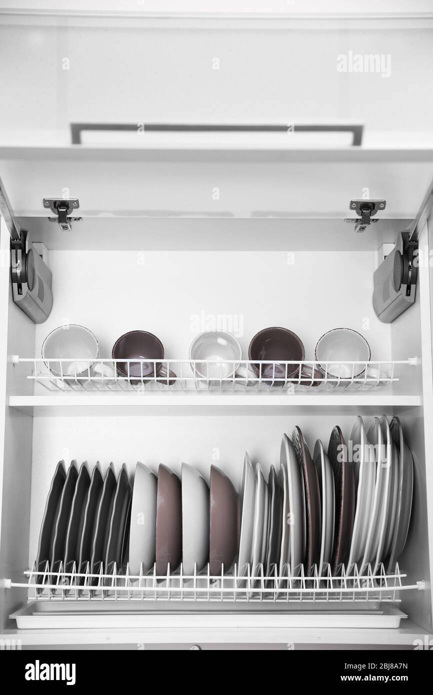 Clean dishes drying on metal dish racks on shelves Stock Photo Alamy