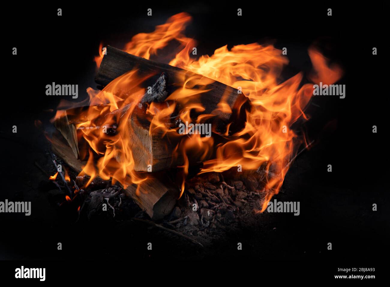 Fire flames with sparks on  coals on black background Stock Photo