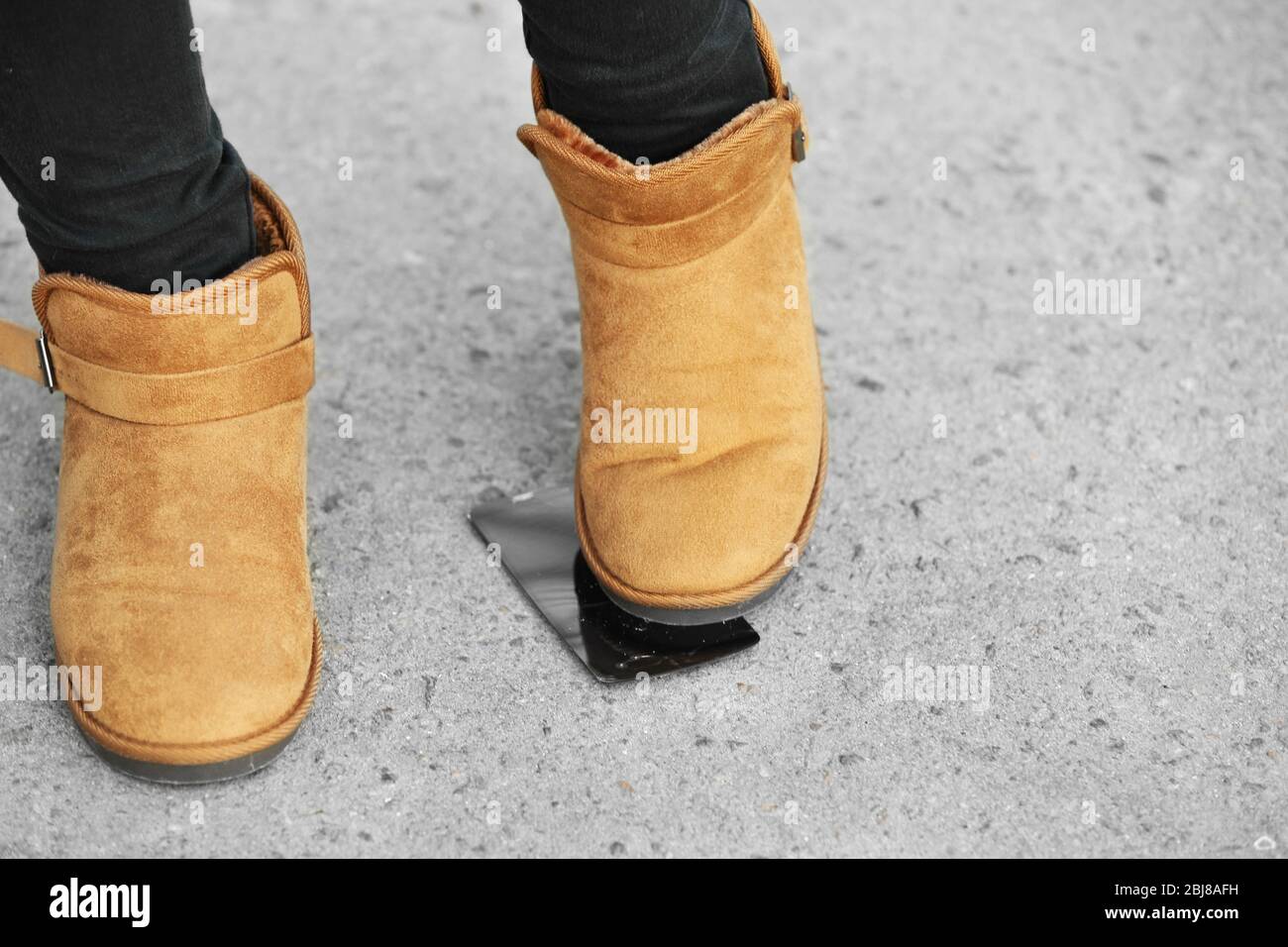 Female boots crushing a mobile phone on the pavement Stock Photo - Alamy