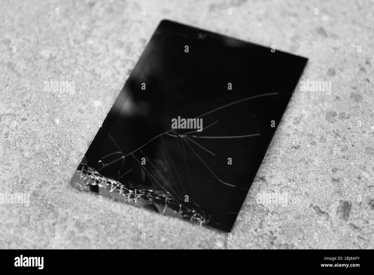 Broken tablet with cracked screen on the pavement Stock Photo
