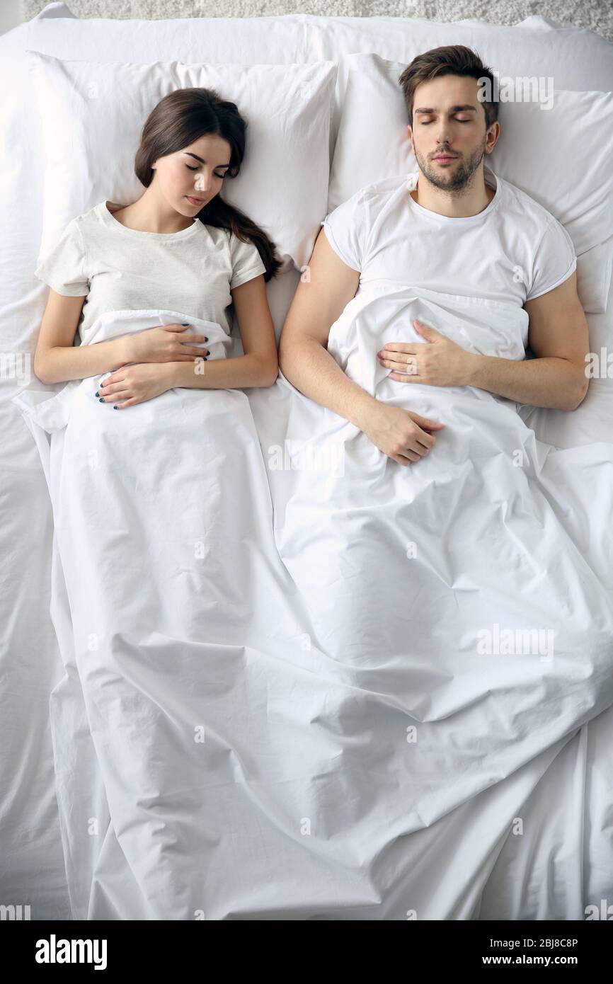 Young cute couple sleeping together in bed Stock Photo - Alamy