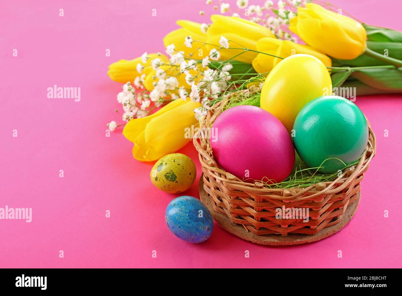 Multicoloured Easter eggs and tulips on pink background Stock Photo - Alamy