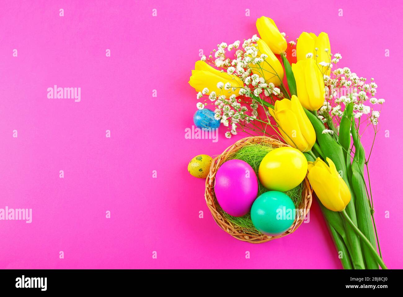 Multicoloured Easter eggs and tulips on pink background Stock Photo - Alamy