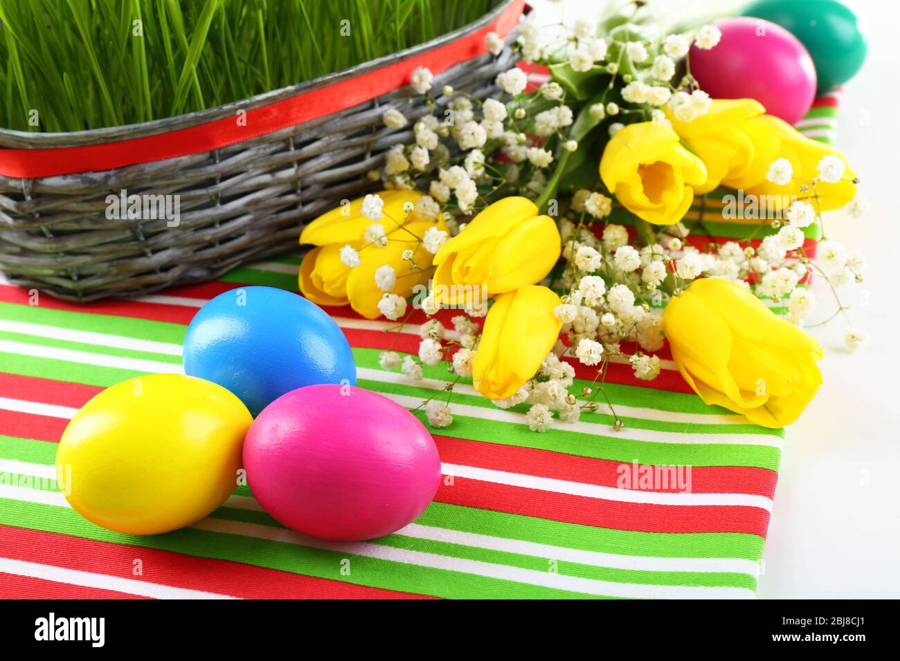 Multicoloured Easter eggs and tulips on napkin, closeup Stock Photo - Alamy
