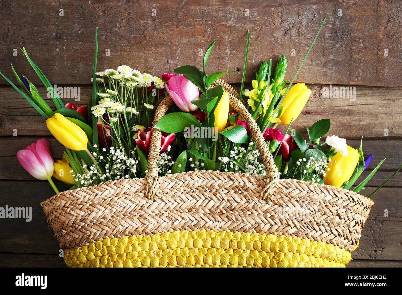 Bouquet of fresh flowers in a wicker basket Stock Photo - Alamy