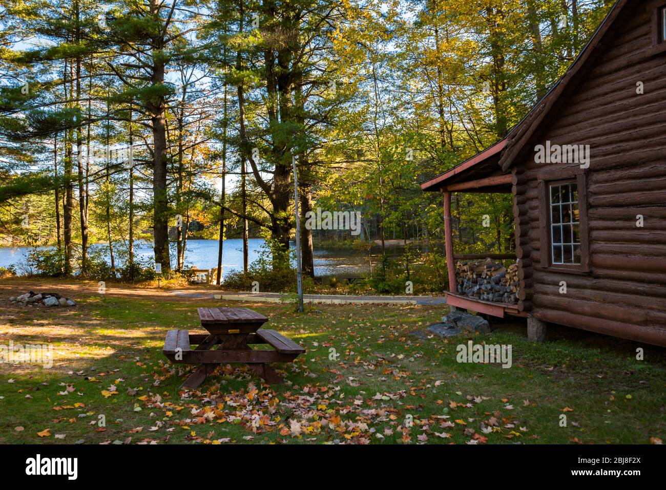 Rustic Lakeside Cabin Resort with Log Cabin, Picnic Table, Camp Fire Pit, & Lake Stock Photo
