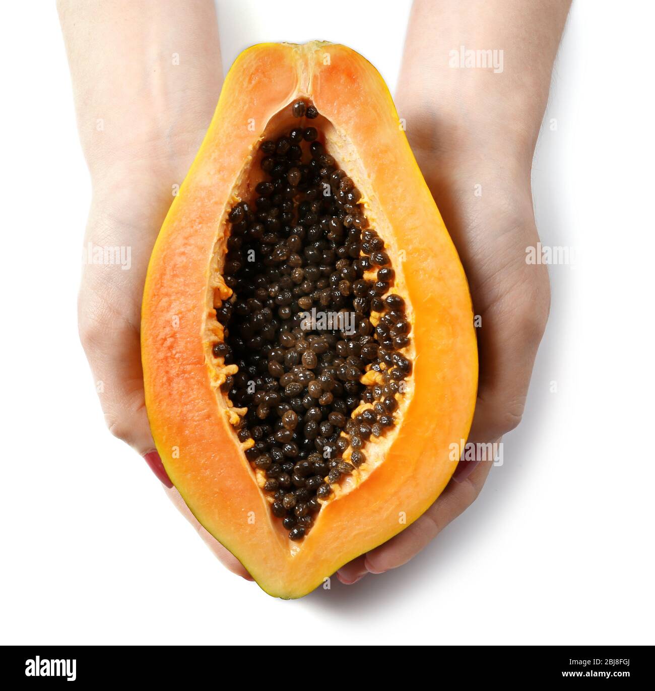 Female hands holding a halved papaya on white background Stock Photo
