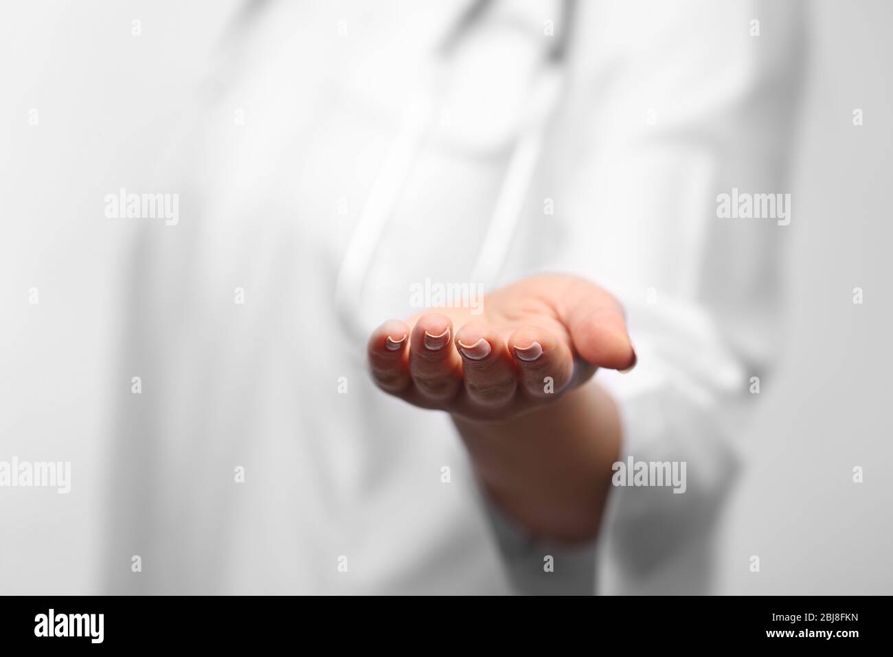 Young female doctor with outstretched hand Stock Photo