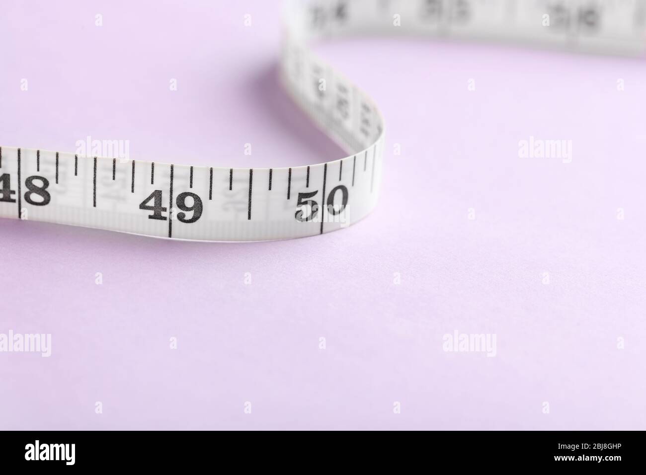 Measuring Tape, Purple And Black, For Sewing Uncoiled On A White  Background. Stock Photo, Picture and Royalty Free Image. Image 5385974.