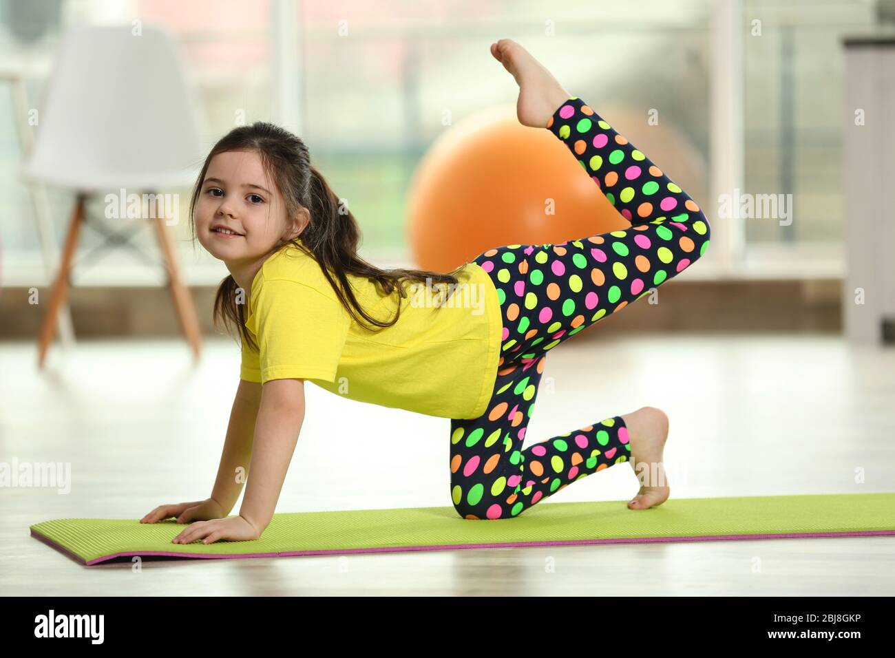 Little cute girl practicing yoga pose on a mat indoor Stock Photo - Alamy