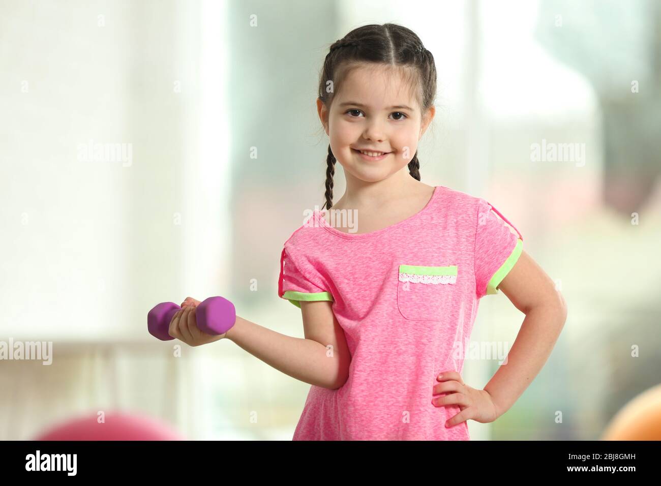 Little cute girl doing exercises with dumbbells indoor Stock Photo - Alamy