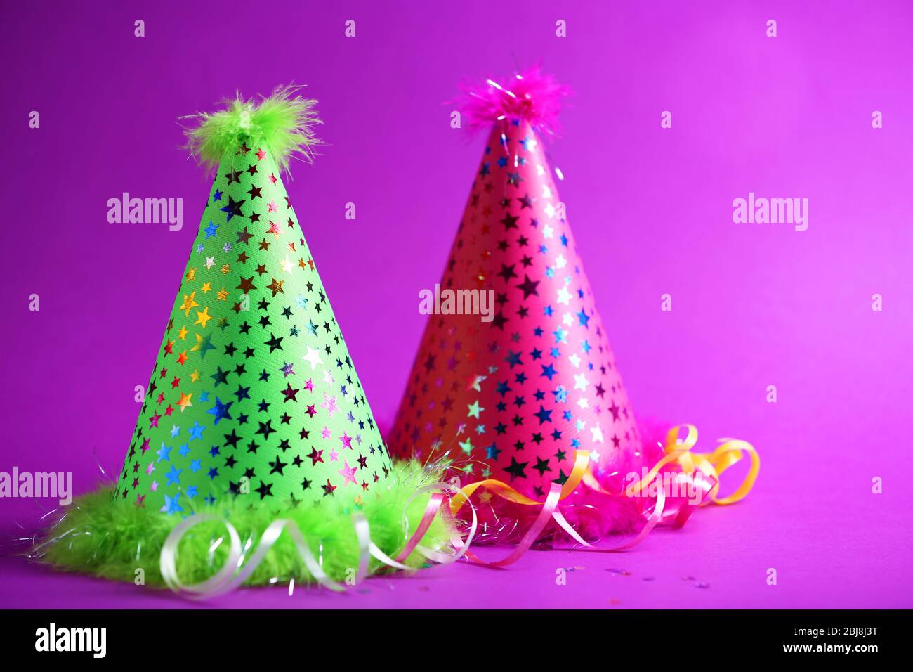 Funny party hats on purple background Stock Photo Alamy