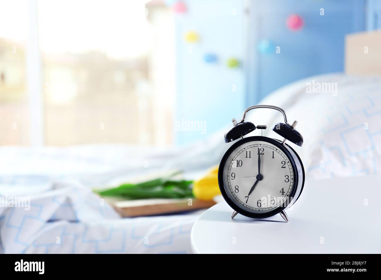 Vintage alarm clock on bedside table in a room Stock Photo