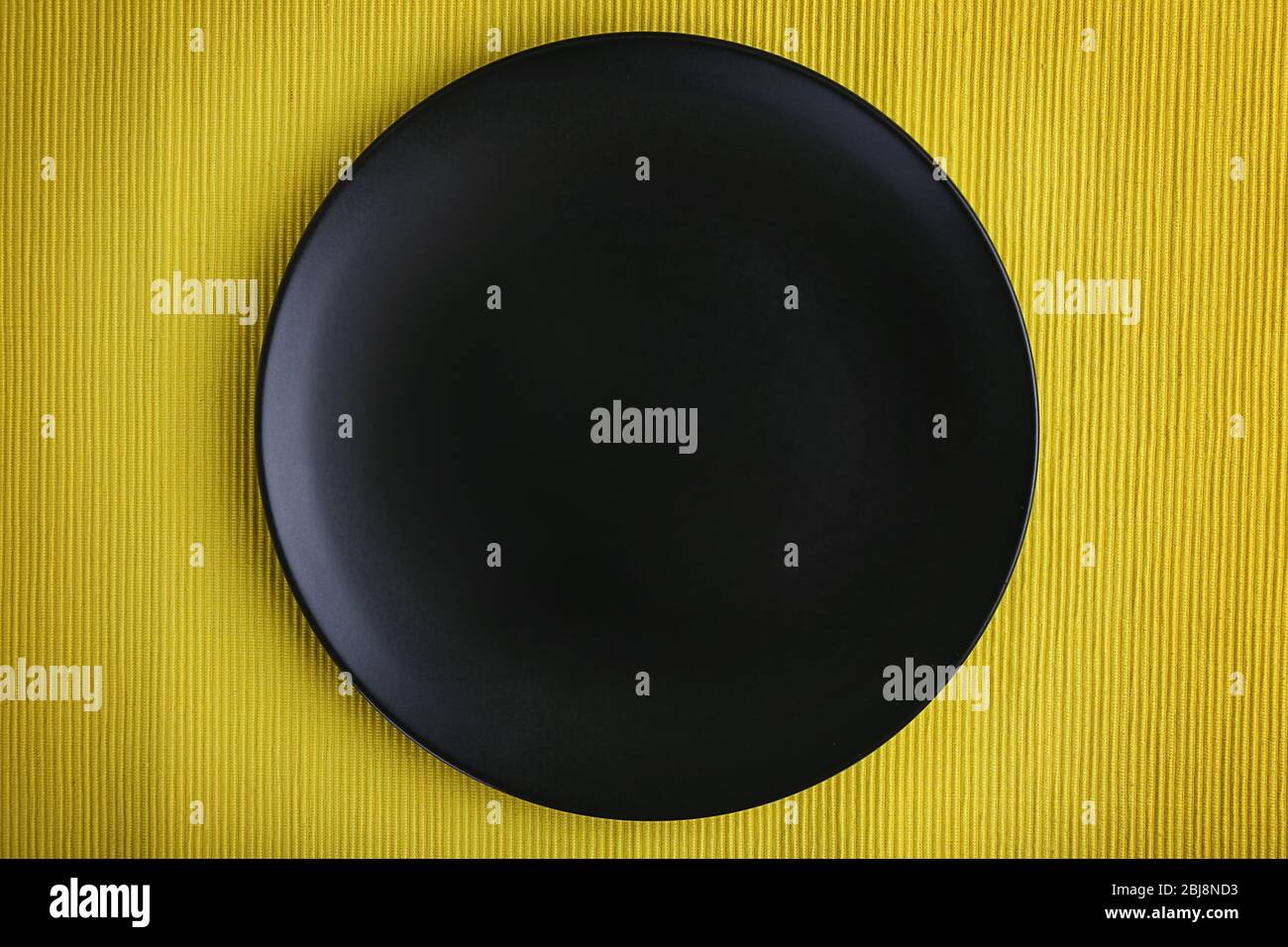 Empty plate on yellow textured background Stock Photo