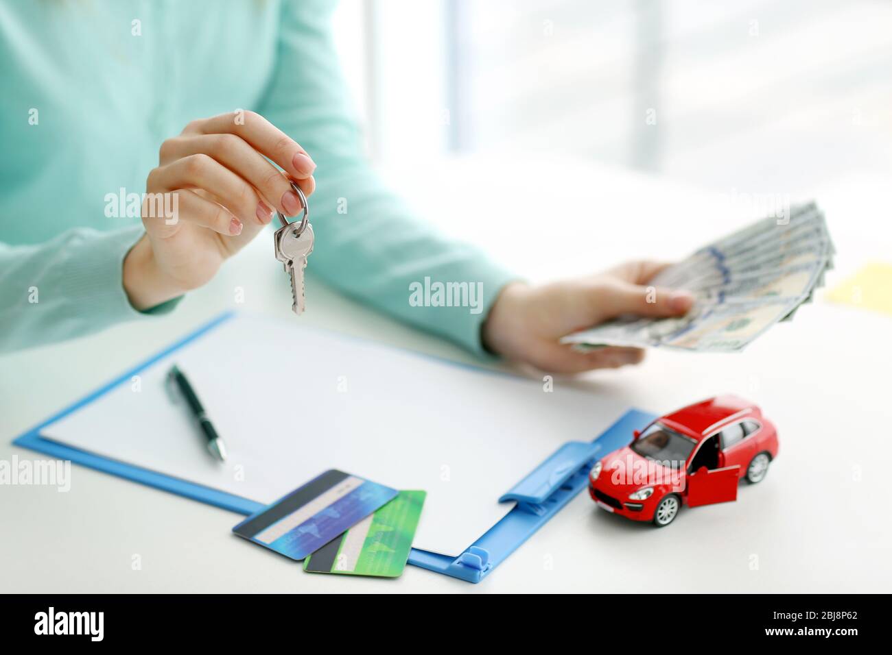 Buying  a new car concept. Hands holding money and keys. Stock Photo
