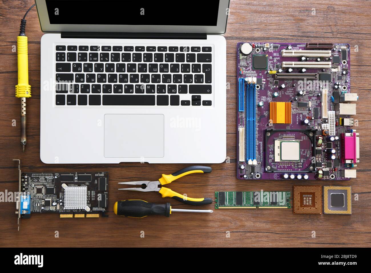 Laptop and different electronic circuits, tools on wooden table, top view Stock Photo