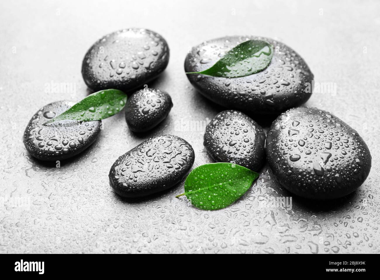 Heap of spa hot stones on grey background Stock Photo - Alamy