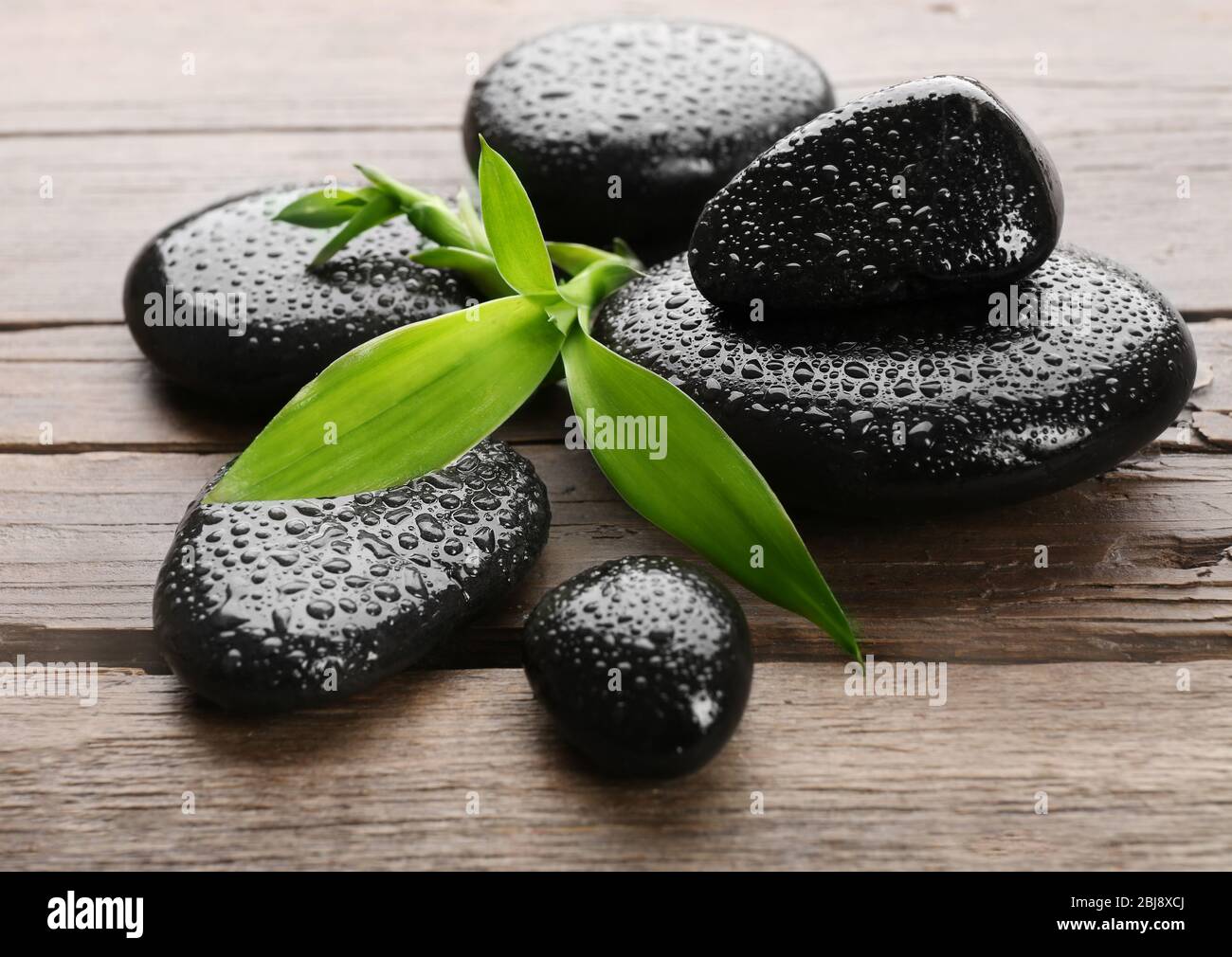 Heap of spa hot stones on wooden table Stock Photo - Alamy