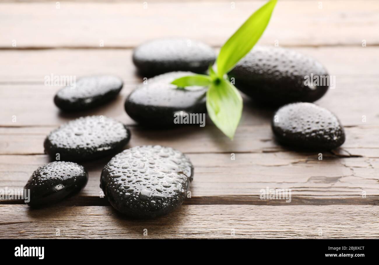 Heap of spa hot stones on wooden table Stock Photo - Alamy