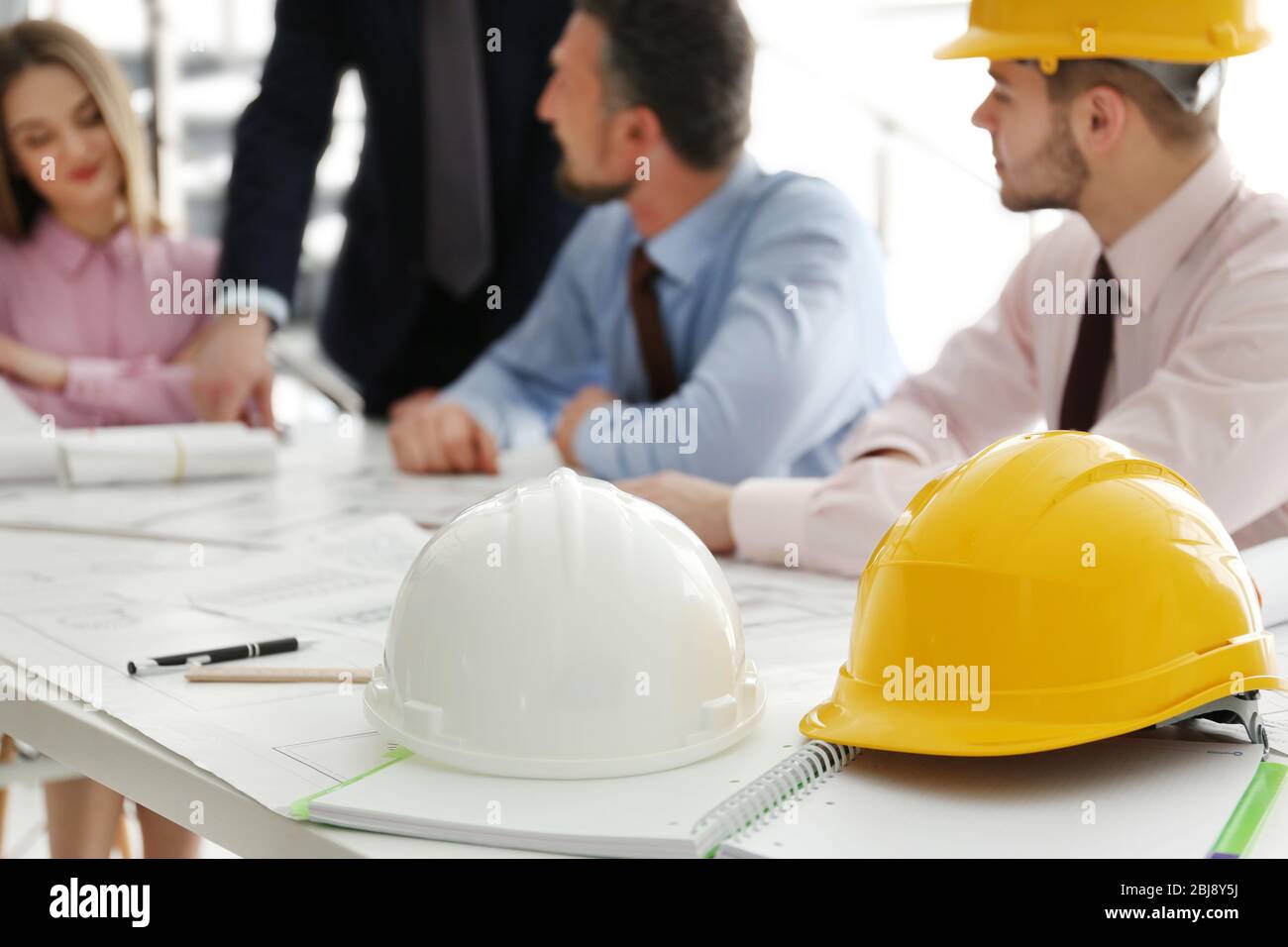Helmets and blueprints on the office table Stock Photo