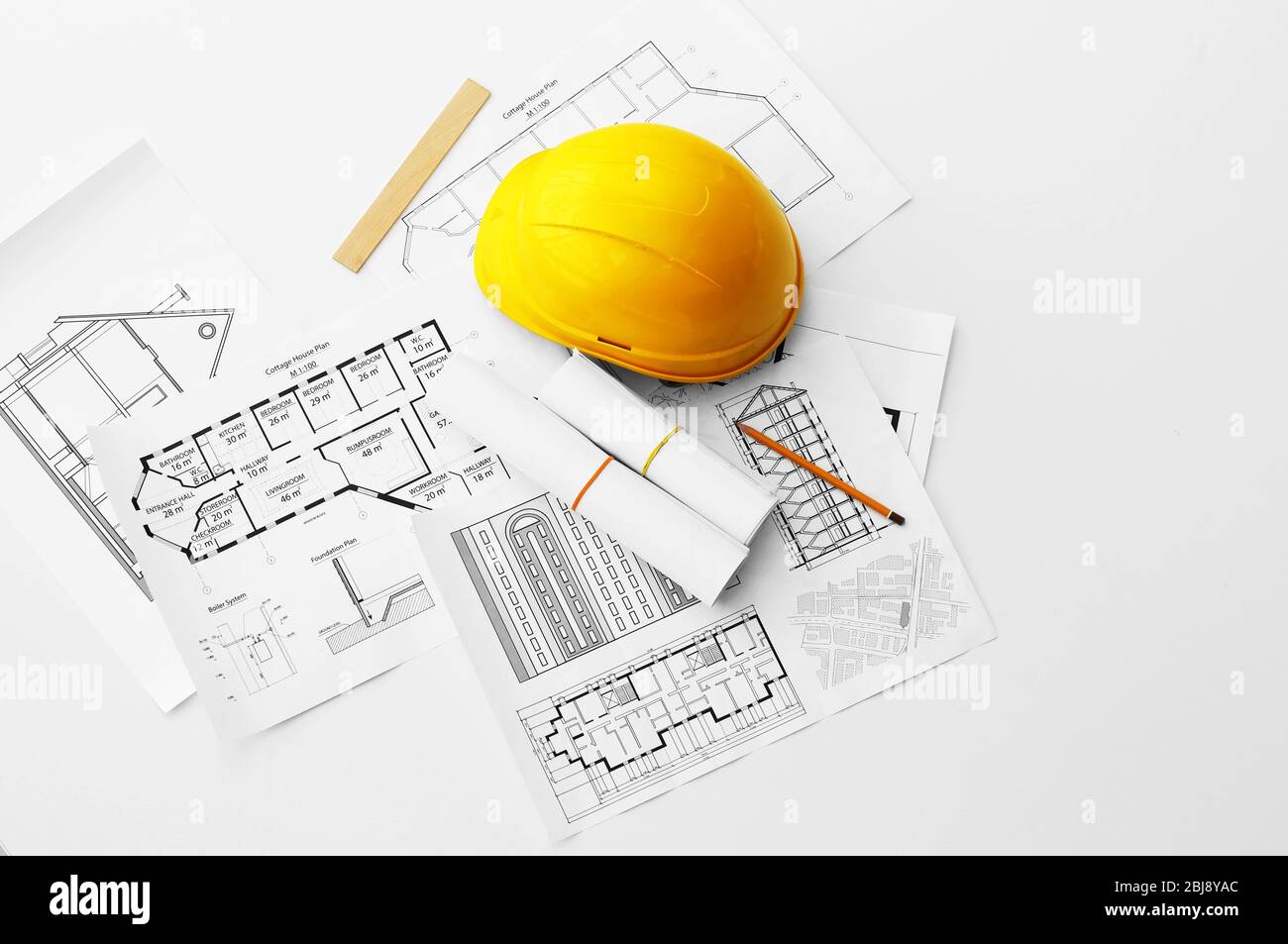 Yellow helmet on the table with blueprints Stock Photo - Alamy
