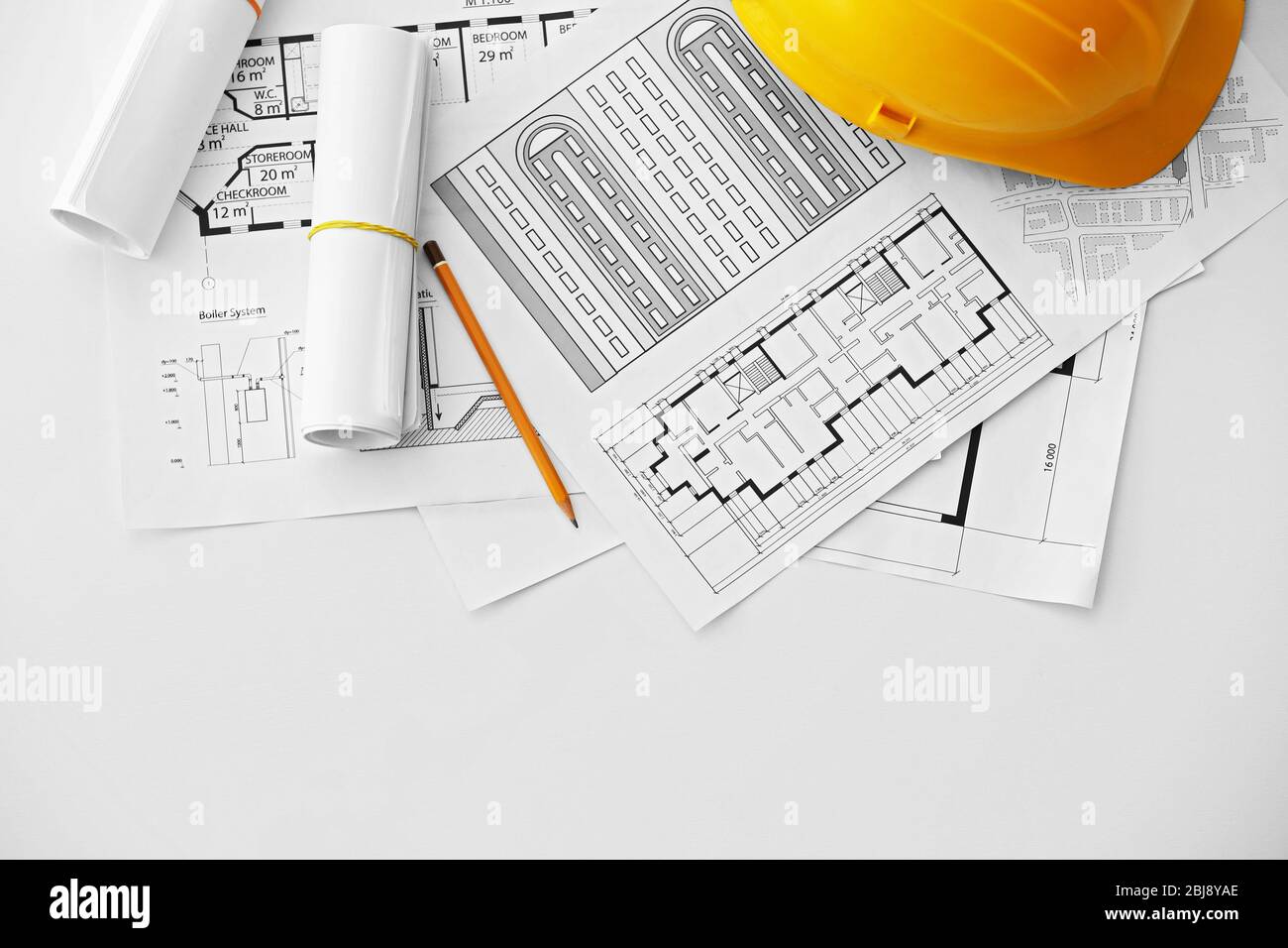 Yellow helmet on the table with blueprints Stock Photo - Alamy