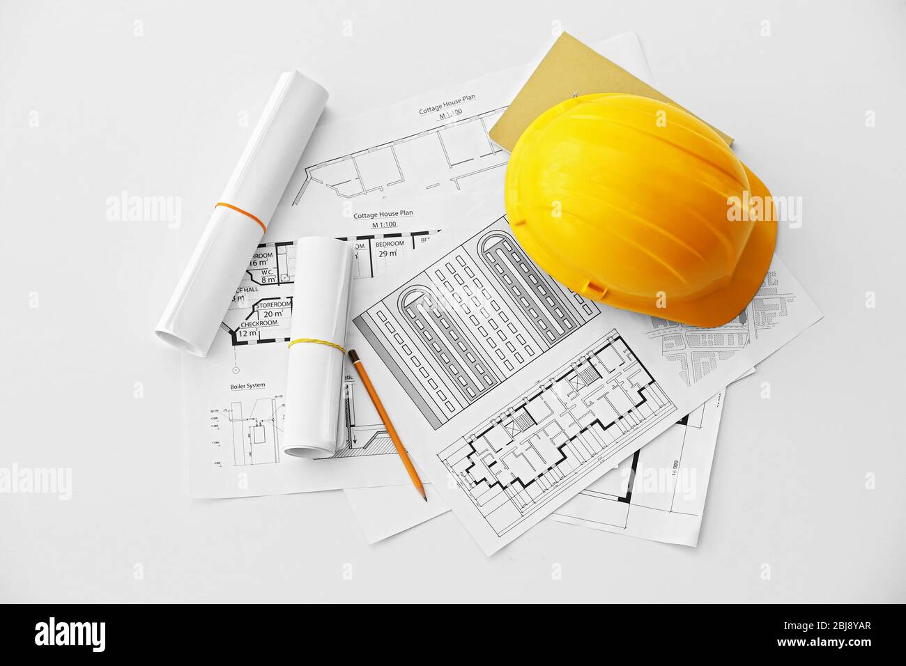 Yellow helmet on the table with blueprints Stock Photo - Alamy