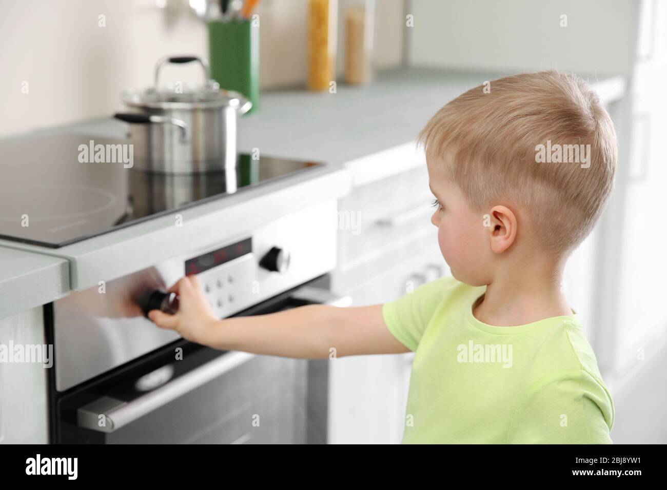 Little child playing with electric stove in the kitchen Stock Photo Alamy