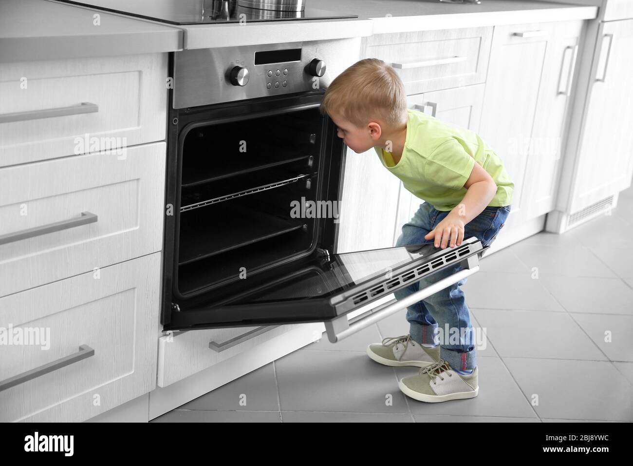 Little child playing with electric stove in the kitchen Stock Photo Alamy