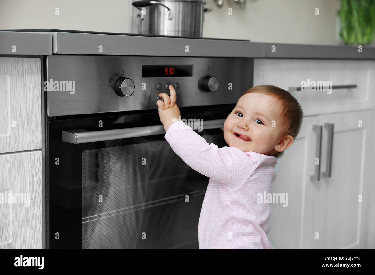 https://c8.alamy.com/comp/2BJ8YY4/little-child-playing-with-electric-stove-in-the-kitchen-2BJ8YY4.jpg