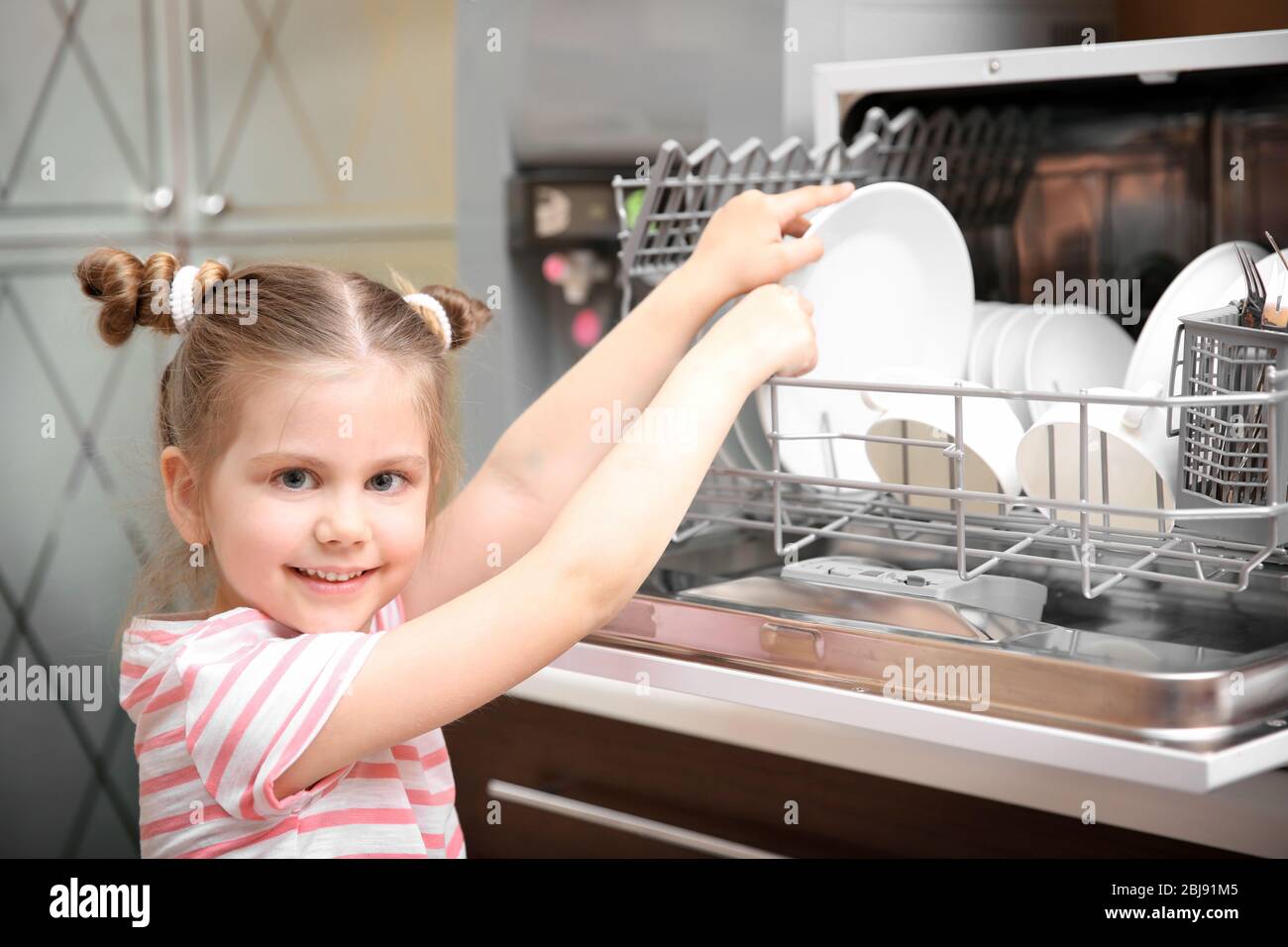 Little girl playing with dishwasher in kitchen Stock Photo Alamy