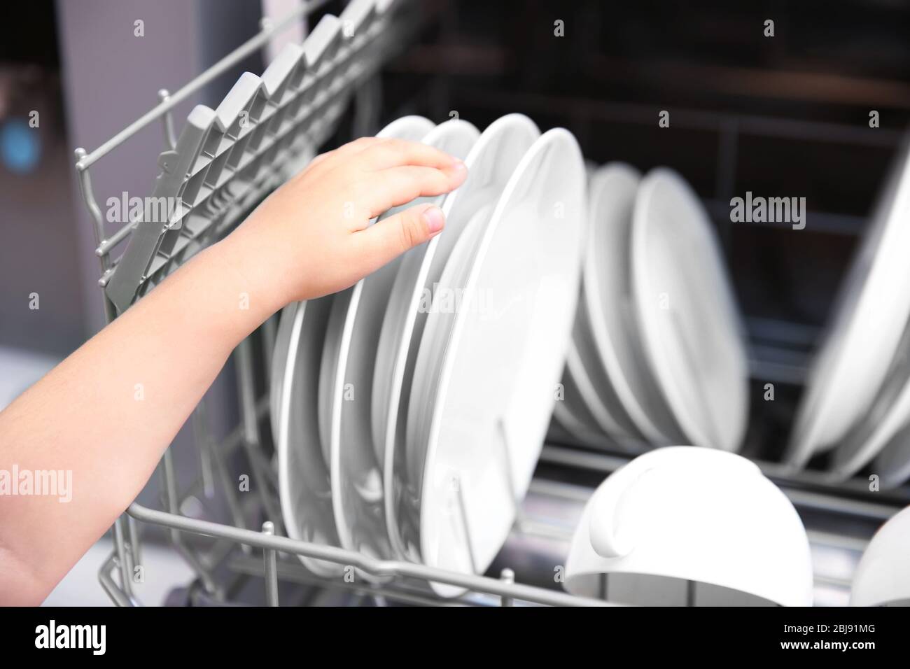 Little girl taking plates from the dishwasher, closeup Stock Photo Alamy