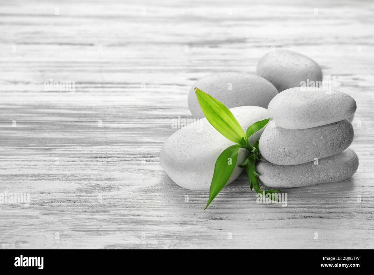 Heap of spa hot stones on white wooden background Stock Photo - Alamy