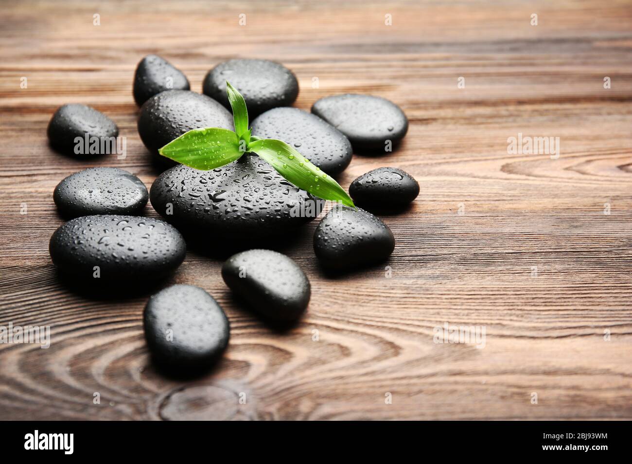Heap of spa hot stones on wooden background Stock Photo - Alamy