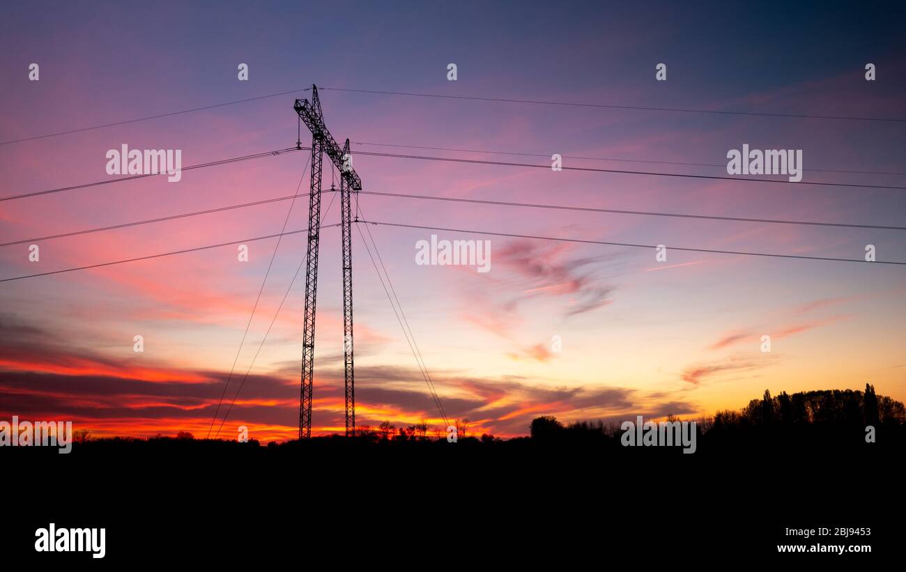 Silhouette of high voltage electric tower at beautiful sunset with ...