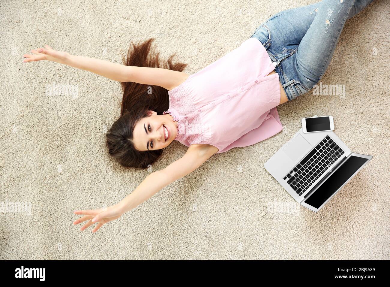 Beautiful girl with laptop lying on floor Stock Photo - Alamy