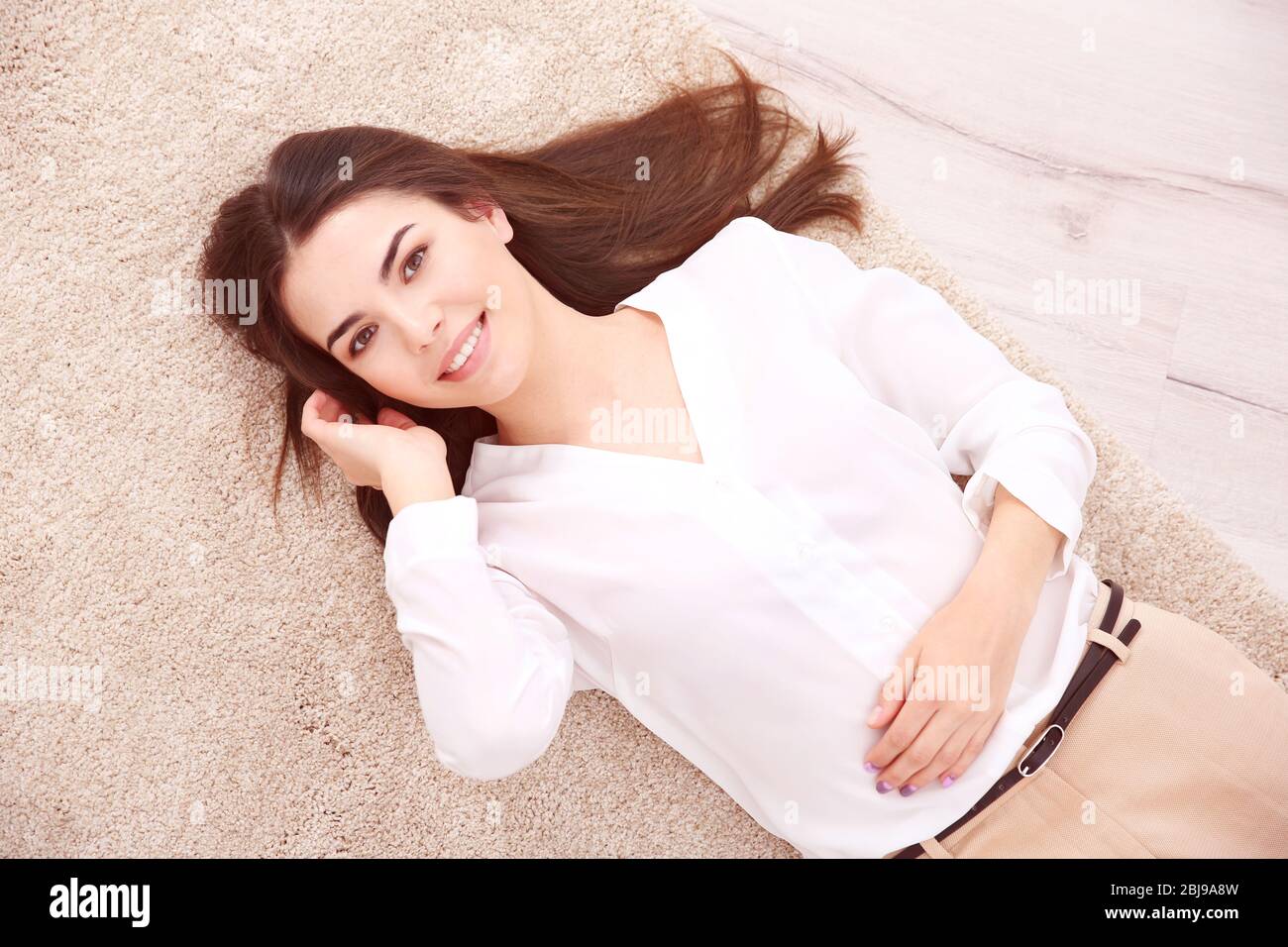 Beautiful girl lying on floor Stock Photo - Alamy