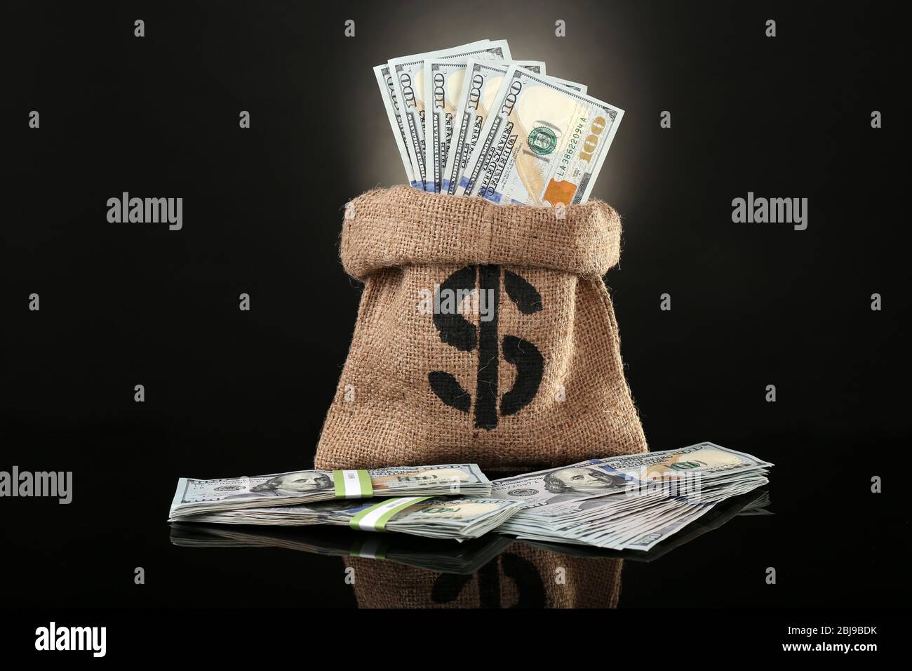 Money bag with dollars on black background Stock Photo - Alamy