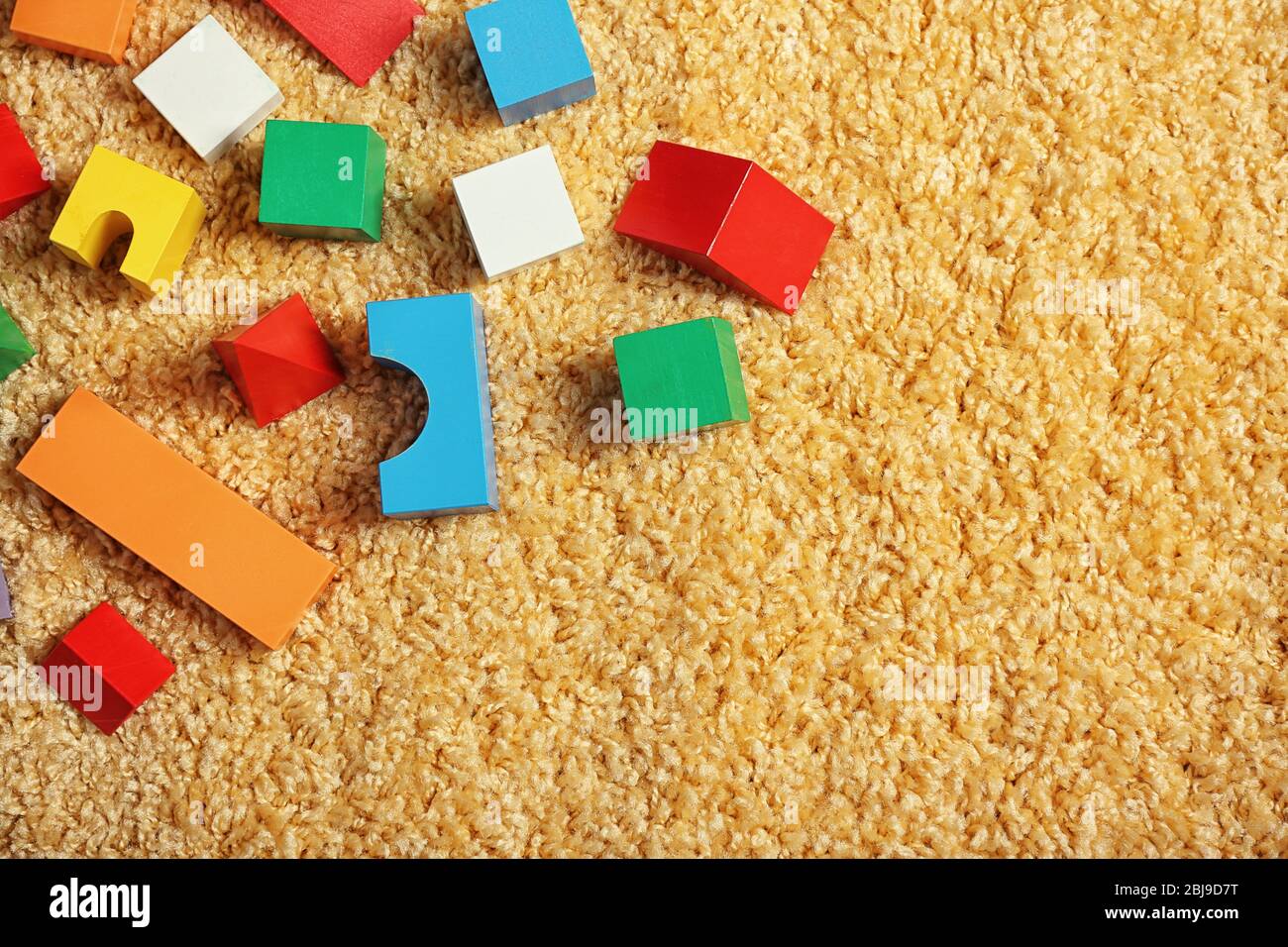 Colorful wooden kids toys on carpet Stock Photo - Alamy