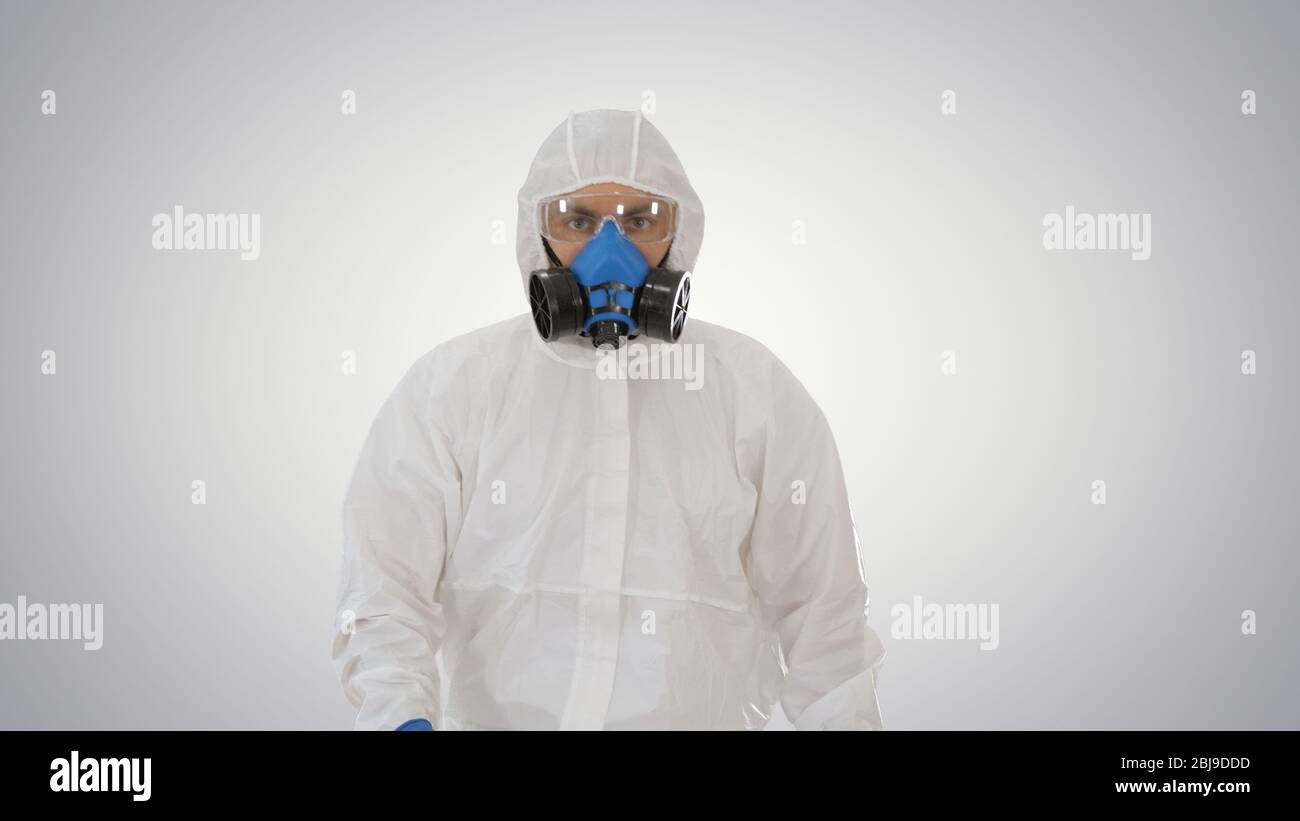 Man wearing hazmat suit walking on gradient background. Stock Photo