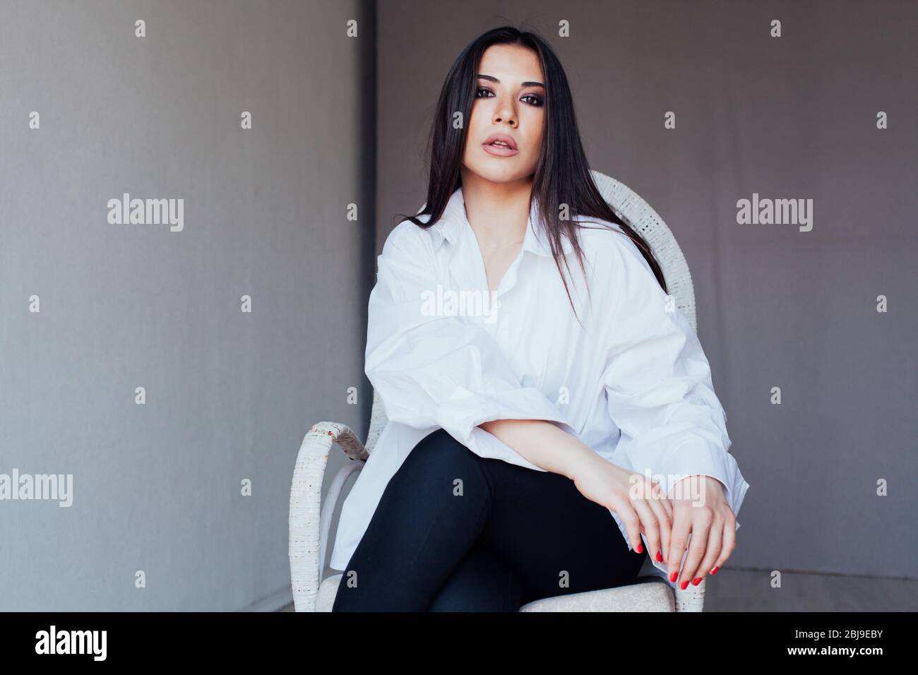 Beautiful fashionable eastern brunette woman in white shirt Stock Photo ...