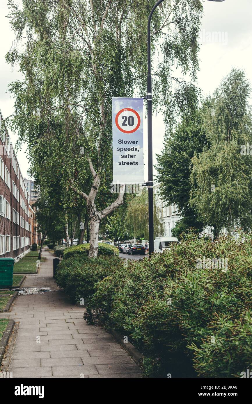 Billboard on a pillar showing twenty miles per hour speed limit sign and the inscription 'Slower speeds, safer streets' on it instilling safe drive in Stock Photo
