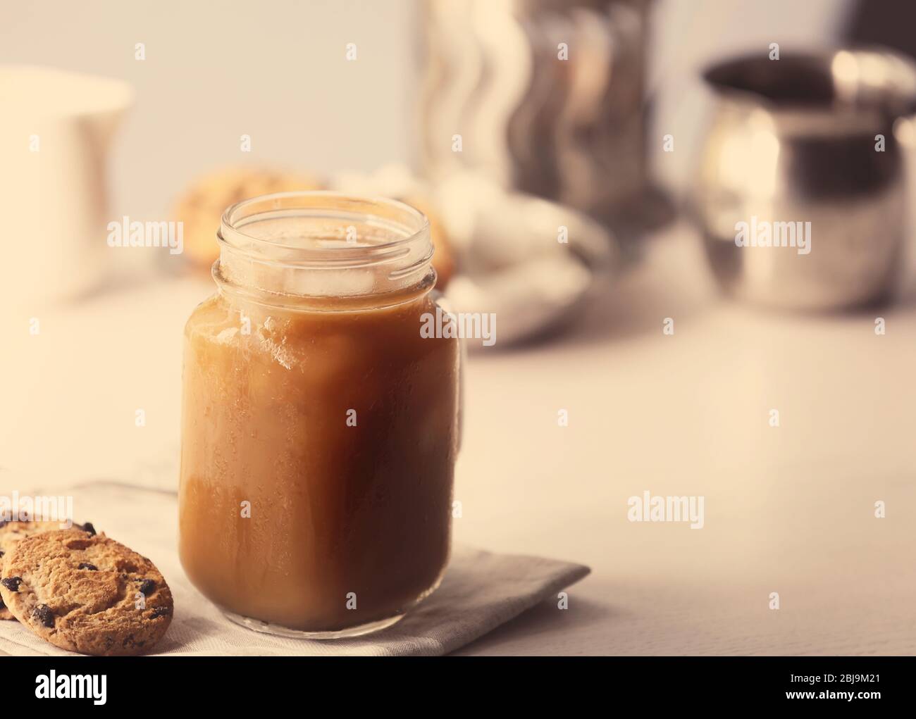 Iced coffee in glass jar and cookies on white table Stock Photo Alamy
