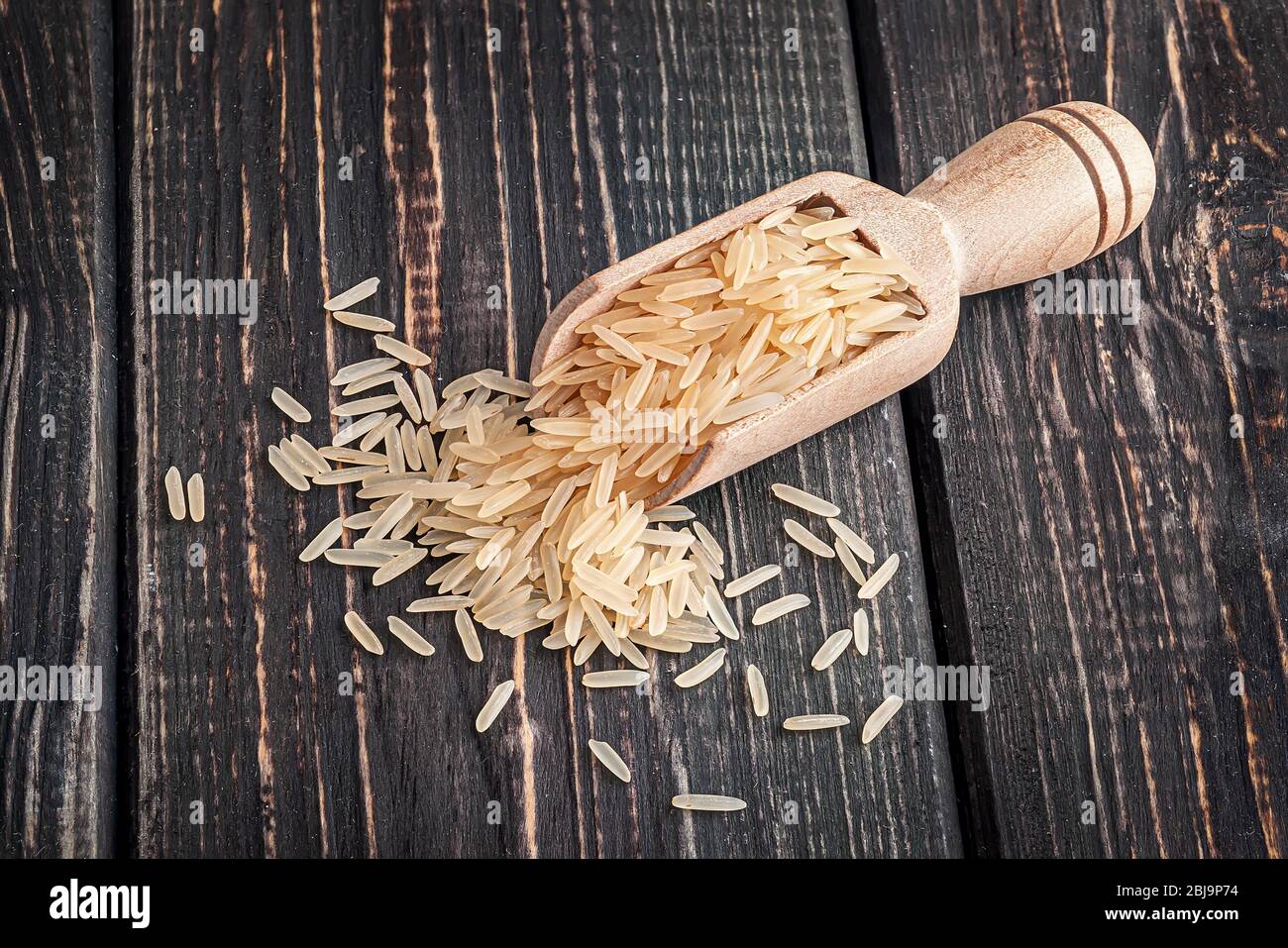 Long rice in wooden scoop Stock Photo