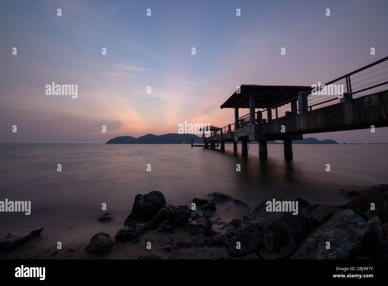 Sunray over Jetty Batu Musang Stock Photo - Alamy