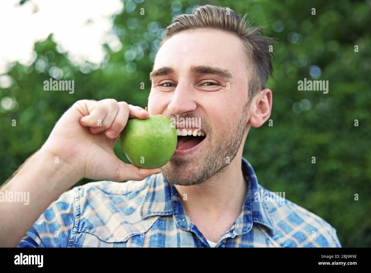 Handsome man eating apple, closeup Stock Photo Alamy
