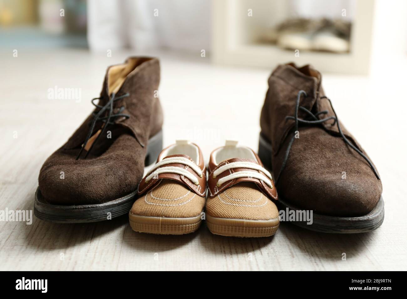 Big and small shoes on wooden floor Stock Photo - Alamy