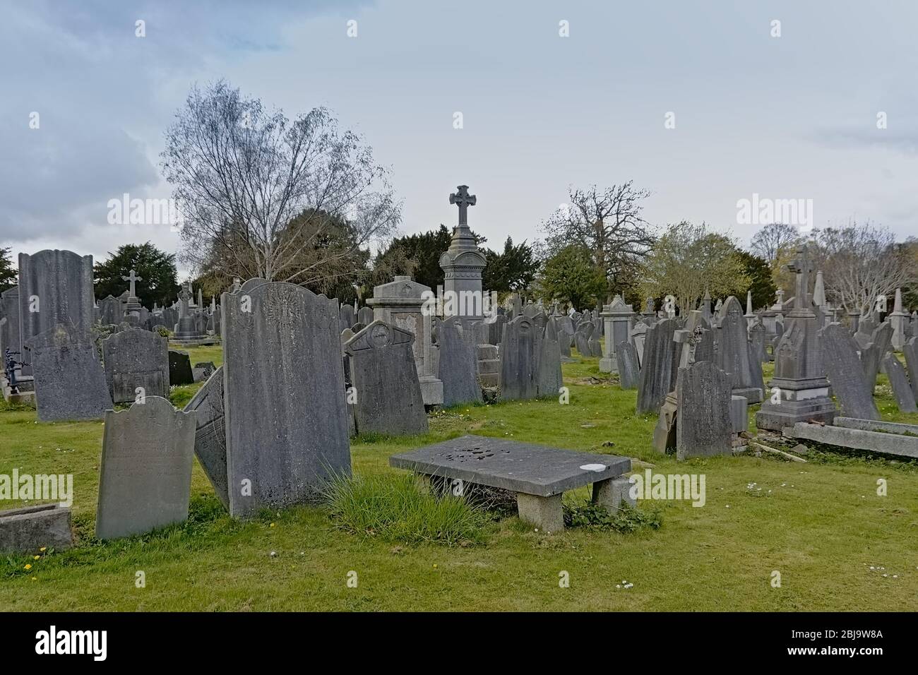 Spooky old decayed grave monuments with crosses in Glasnevin, green ...